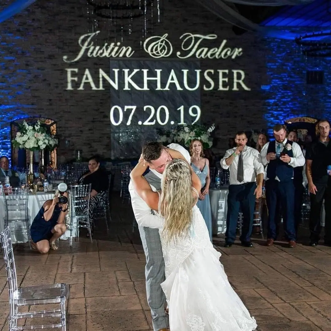 Couple’s names projected on a stone wall in custom monogram lighting during their first dance